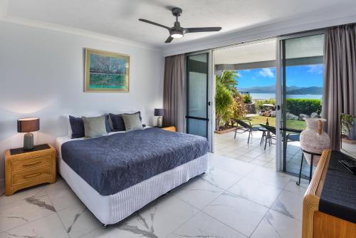 a bedroom with a bed and a view of the ocean at Frangipani Beachfront Lodge F5 on Hamilton Island by HamoRent in Hamilton Island
