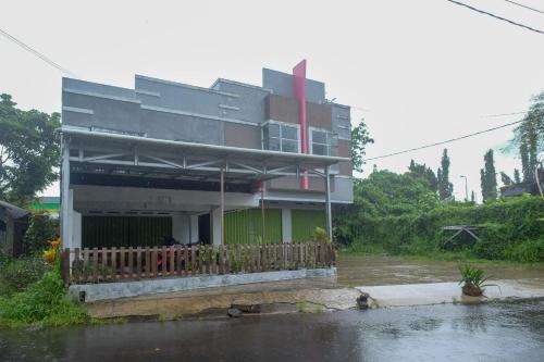 a house on a flooded street in front of a building at RedDoorz at Lapangan Bandara Sam Ratulangi Manado in Manado