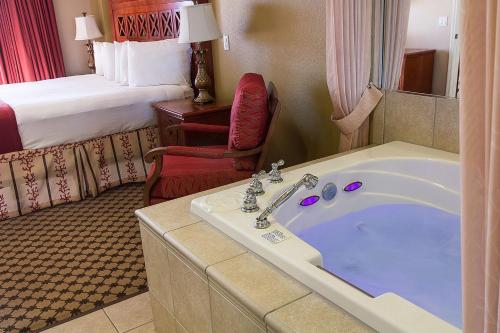 une chambre d'hôtel avec une baignoire et un lit dans l'établissement STUNNING CONDO NEAR UNIVERSAL STUDIOS, à Orlando