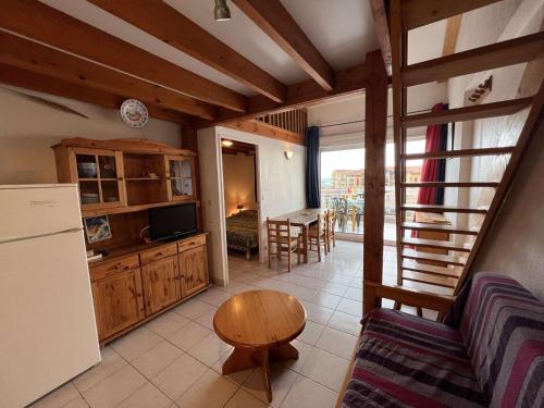 Il comprend une cuisine équipée d'un canapé, d'une table et d'un réfrigérateur. dans l'établissement Appartement T2 Mezzanine, 6 personnes, proche plage, parking, Valras-Plage - FR-1-701-39, à Valras-Plage