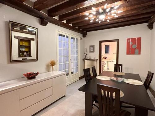 une cuisine et une salle à manger avec une table et des chaises dans l'établissement Gîte de charme à Artenay : 5 chambres, jardin clos, proche Orléans et Paris, idéal familles et amis - FR-1-590-269, à Artenay