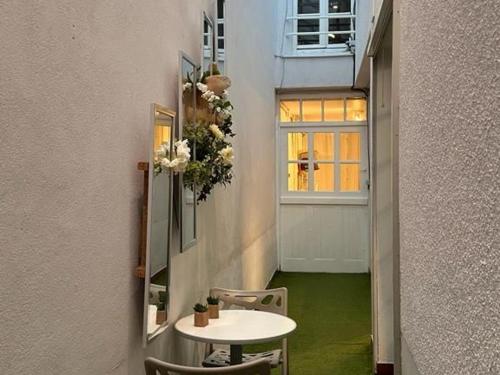 une petite table et des chaises dans un couloir avec une porte dans l'établissement Gîte de charme à Artenay : 5 chambres, jardin clos, proche Orléans et Paris, idéal familles et amis - FR-1-590-269, à Artenay