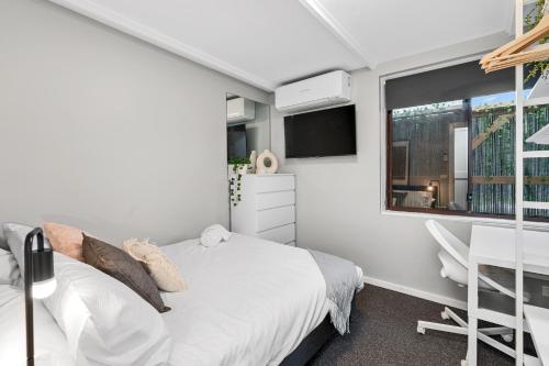 1 dormitorio con cama, escritorio y ventana en Quite, quaint & private guesthouse, sleeps 6, en Melbourne