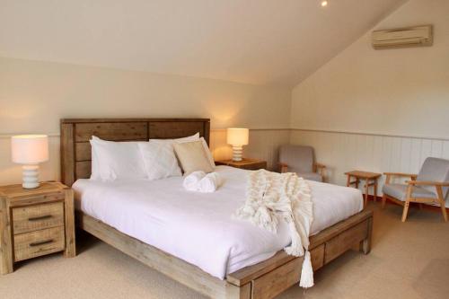 a bedroom with a large bed with two towels on it at Banksia in Port Campbell