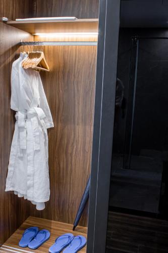 a wardrobe with a white dress and blue flip flops at Grand Tourane Nha Trang Hotel in Nha Trang