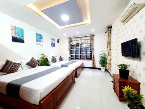 ein großes Schlafzimmer mit 2 Betten und einem TV in der Unterkunft HM Villa - Free Pick-up Mỹ Khê Beach in Đà Nẵng