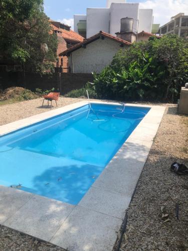 a blue swimming pool in front of a house at Panorama Villa Gesell in Villa Gesell