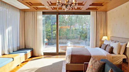 a bedroom with a bed and a couch and a large window at Bonum 1957 Hanok and Boutique in Seoul