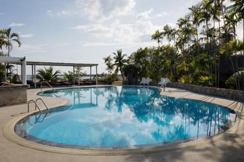 una piscina en un complejo con palmeras en Bann Pae Cabana Hotel And Resort, en Klaeng