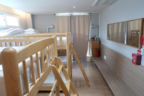 a bedroom with two bunk beds and a ladder to a bed at Andong Poong-gyung HOSTEL n LIBRARY in Andong