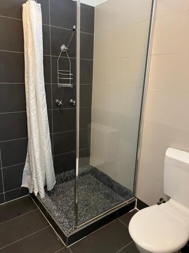 a shower with a glass door and a toilet at Akara Perth in Perth