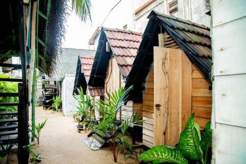 a small wooden building with plants in a courtyard at Brother's Beach Home in Galle
