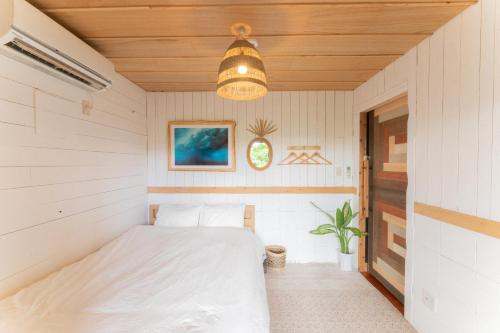 Mambo Hostel Okinawa في موتوبو: غرفة نوم في بيت فيه سرير