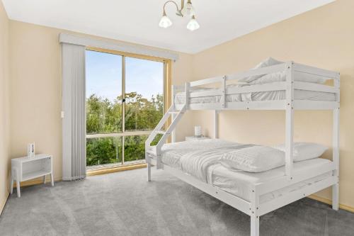 ein Schlafzimmer mit einem weißen Etagenbett und einem Fenster in der Unterkunft Vantage Point in Corinella