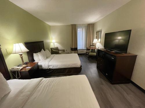 a hotel room with two beds and a flat screen tv at Comfort Inn Pinehurst - Southern Pines in Pinehurst
