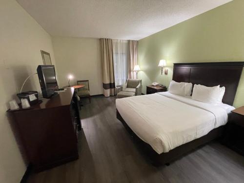 a hotel room with a large bed and a television at Comfort Inn Pinehurst - Southern Pines in Pinehurst
