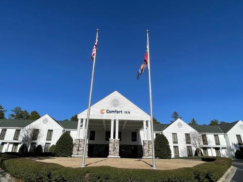 a building with two flags in front of it at Comfort Inn Pinehurst - Southern Pines in Pinehurst
