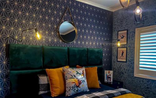 a bedroom with a green couch and a mirror at Abusar Apartment in Boksburg