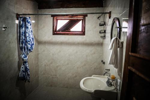 uma casa de banho com um lavatório e um chuveiro com uma janela em Lucero em Mazamitla