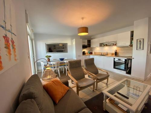 un salon avec un canapé et une cuisine dans l'établissement Appartement lumineux 3 chambres à 400m des plages avec parking et WIFI - FR-1-413-113, à Capbreton