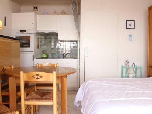 une cuisine et une salle à manger avec une table et un lit dans l'établissement Studio agréable 4 pers. avec terrasse et parking, La Baule - FR-1-245-133, à La Baule