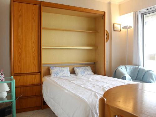um quarto com uma cama e uma cabeceira em madeira em Appartement La Baule, 1 pièce, 4 personnes - FR-1-245-133 em La Baule