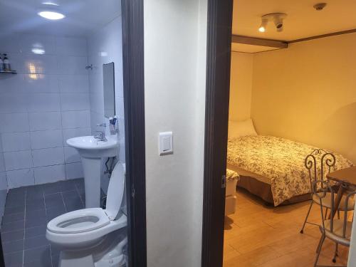 a bathroom with a toilet and a sink and a bed at G Mini Hotel Dongdaemun in Seoul