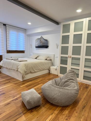 a bedroom with a large bed and a chair at Arriaga 1 in Marquina
