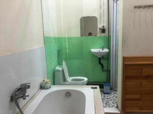 a bathroom with a tub and a toilet and a sink at Hoàng Gia Bảo Hotel in Kon Tum