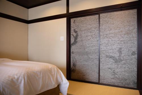 Postel nebo postele na pokoji v ubytování Kamisuwa Onsen Shinyu