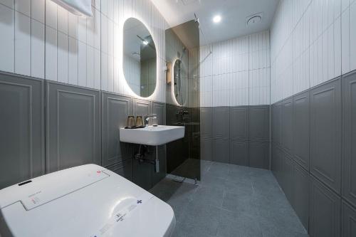 a white bathroom with a sink and a toilet at Browndot Hotel Mokpo Gotbawi in Mokpo