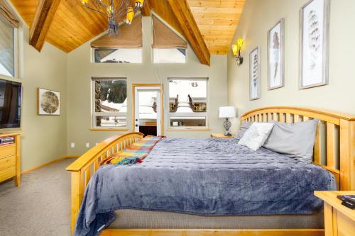 a bedroom with a wooden bed with a blue comforter at Mountain Chalet in Girdwood