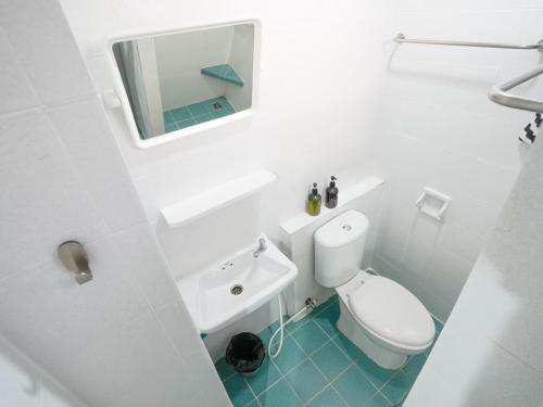 een badkamer met een toilet, een wastafel en een spiegel bij Suksomboon Residence in Bangkok