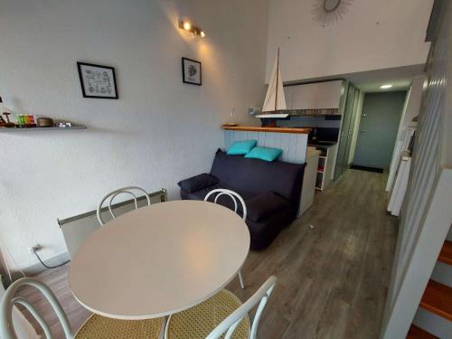 un salon avec une table et un canapé dans l'établissement Appartement climatisé 2 pièces à 160m de la plage avec terrasse, parking privé et proche commerces - FR-1-423-240, au Grau-dʼAgde
