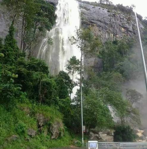 a waterfall on the side of a mountain at Diyaluma View Cotage in Koslanda