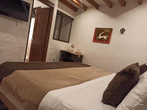 a bedroom with two beds and a flat screen tv at HOTEL LA POSADA DEL ZAGUÁN in El Retiro