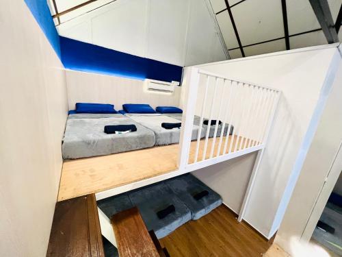 a small room with a bed and a staircase at KASIH SAYANG Farmstay山下人家 in Kluang