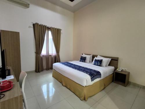 een slaapkamer met een groot bed en een raam bij Tanto Hotel in Waingapu