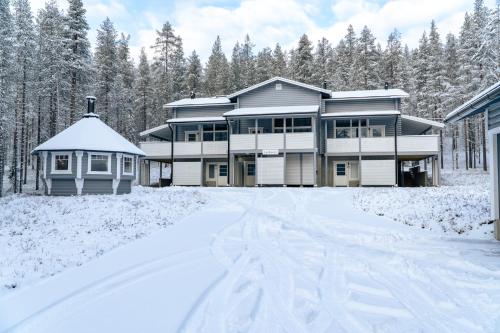 une maison dans la neige avec des arbres en arrière-plan dans l'établissement Holiday in Lapland - Levihovi 6B, à Levi