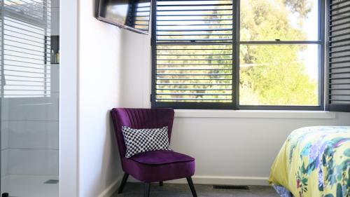 a purple chair in a bedroom with a window at LACROIX - DAYLESFORD in Daylesford