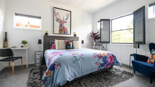 a bedroom with a bed and a desk and windows at LACROIX - DAYLESFORD in Daylesford