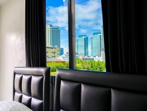 a hotel room with a view of a city from a window at Suksomboon Residence in Bangkok