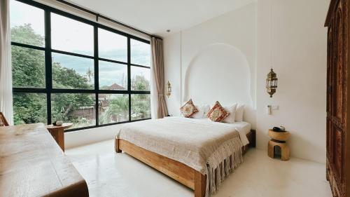 a bedroom with a bed and a large window at Villa Sakinah Canggu in Canggu