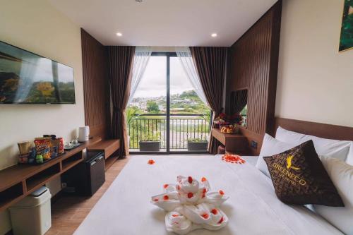 GREENECO DA LAT HOTEL - Khách sạn Green Eco Đà Lạt في دالات: غرفة فندق عليها سرير وفوط