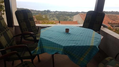 a table on a balcony with a cup on it at CAPITANO di CHERSO VIP holidays, gourmet & sail experience in Dragozetići