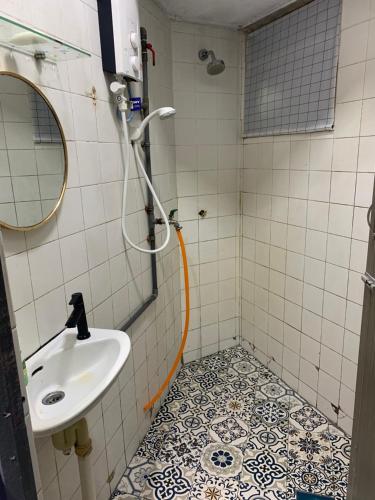 een badkamer met een wastafel en een douche bij JoeRos Homestay in Shah Alam