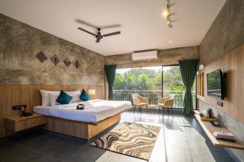 a bedroom with a large bed and a balcony at Zostel Goa, Morjim in Morjim