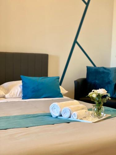 a bed with towels and a vase of flowers on it at Katrina's Home alloggio turistico in Fiumicino