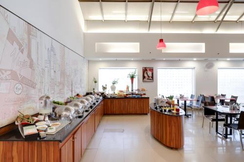 新德里Red Fox by Lemon Tree Hotels, East Delhi的设有自助餐台、桌椅的餐厅