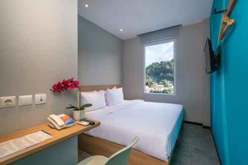 a hotel room with a bed and a window at Rumaruma Farvet Residence @ Ambon in Ambon
